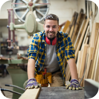 Portrait young motivated carpenter standing by woodworking machine his carpentry workshop